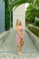 BLONDE AND HANDSOME GIRL WOMAN WITH A BAG IN THE STREET