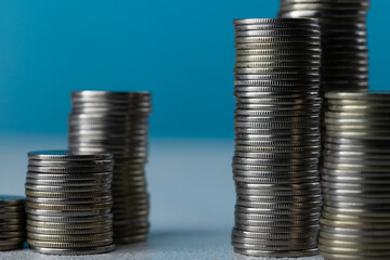 Silver coins in stacks on a blue background