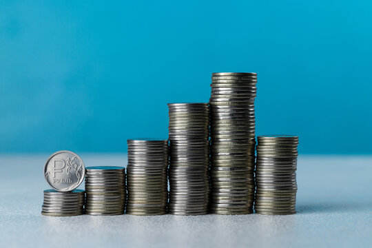 Silver coins in stacks on a blue background