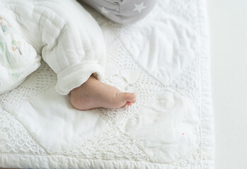 Top view of tiny foot of newborn baby during sleeping on blanket. Newborn baby foot. Asian newborn baby foot