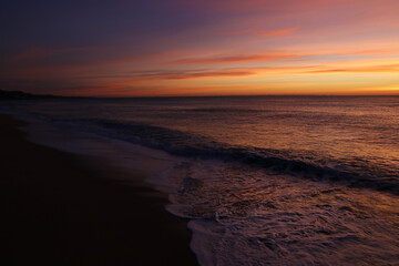 Fototapeta na wymiar Precioso amanecer en el mar con tonos lilas y espuma de mar