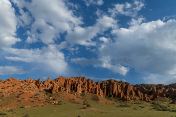 Scenic mountain landscape with red rocks and cloudy sky