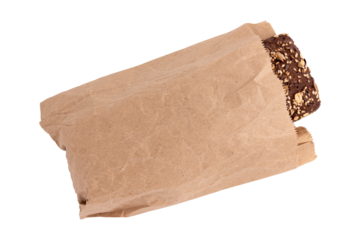 homemade freshly baked traditional rye bread in paper bag isolated on white background, top view, whole rye bread brick with crispy crust and sunflower seeds