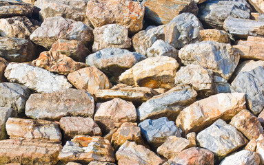 Wall made of rocks and boulders of natural stone - embankment concept