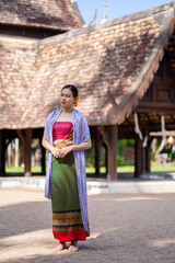 Beautiful Asian women wearing in Thai dress costume traditional according Thai culture and tradition at the ancient wooden temple Chiang Mai, Thailand.Portrait asian Model with smiling