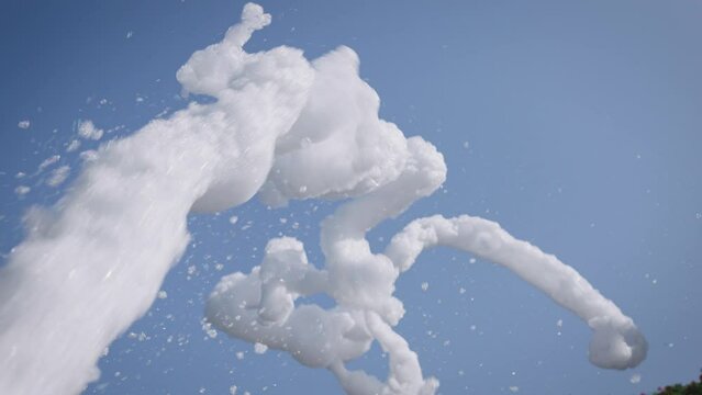 During a foam party, a column of white foam shoots upwards. A foam generator propels the foam into the air, creating a spectacular sight.