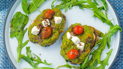 Top view of healthy breakfast with green avocado toast in cafe. Morning Vegan Food. Healthy fat.