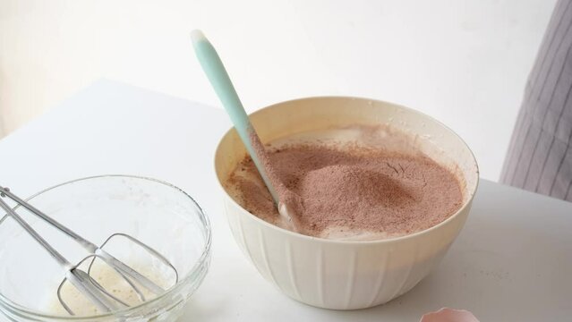 closeup of hand sieving cocoa to dought for cake, slow motion