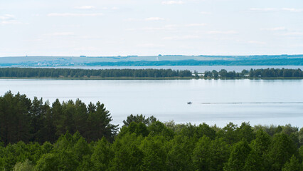 A full-flowing plain river with a motorboat rushing through the water.