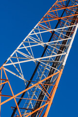 Communications tower with antennas on blue sky