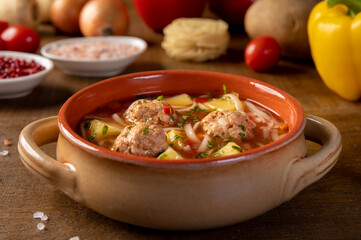 Meatballs soup, romanian traditional food. wooden background. Ciorba de perisoare.