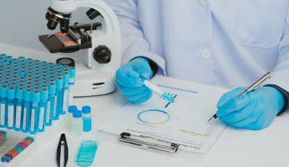 Fototapeta premium Close up view of scientist analyzing a liquid in the test tubes in laboratory.