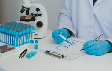 Close up view of scientist analyzing a liquid in the test tubes in laboratory.