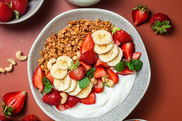 Granola with yogurt, strawberry and banana in a bowl