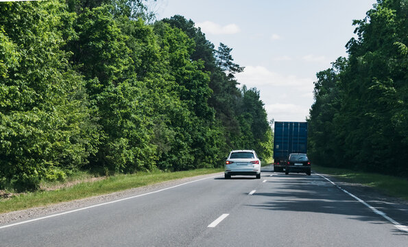 Two cars overtake a truck
