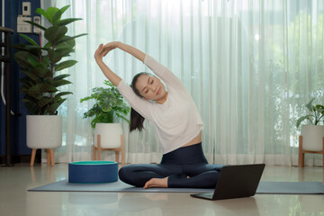 Asian woman doing yoga in living room, concept healthy and care. online course on a video...