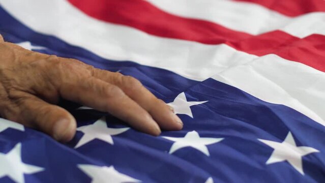 old man's hand on the american flag, veteran of american special services, patriotism and sense of duty, emotions of old people, independence day of america