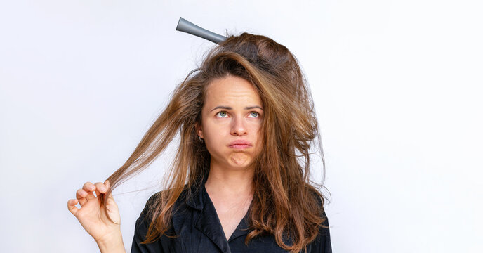 Sad woman combing styling tangled dry  weak hair on a white background.