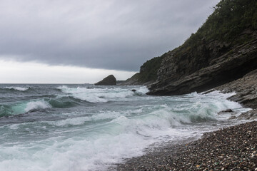 A sea storm.Sea waves are beating against the rock and the seashore.