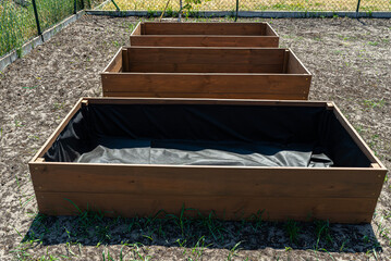 Ready wooden boxes for vegetables lined with agrotextile from the inside.