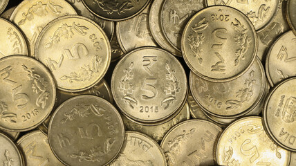 closeup shot of a collection of vintage golden 5 or five rupees in a pile of authentic indian coins
