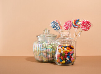 Sweet composition. Candy, marshmallows and lollipops collection on a beige background. Copy space for text.