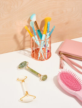 Skincare and beauty routine. Roller facial massagers, brushes for professional makeup or for cosmetic procedures. Pink comb for hair care.