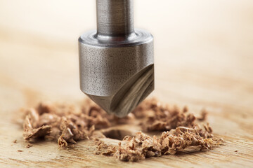 Countersink drill bit with steel triangle ruler make sink in hole for screw in wooden oak plank