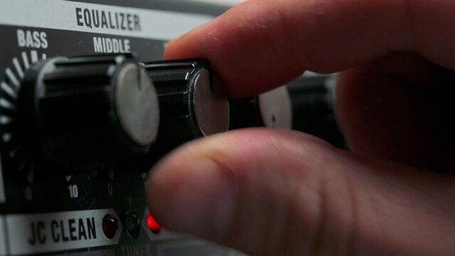 Man adjusting knobs on guitar amplifier. 4k video footage UHD 3840x2160