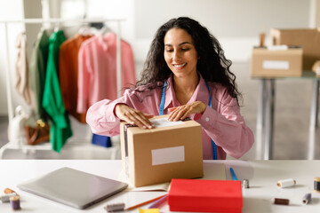 Happy Woman Packing Designer's Clothes In Box In Fashionable Store