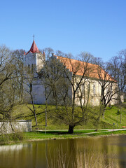 Obraz premium Springtime view through the trees to the Evangelical Lutheran Church of Aizpute, Latvia