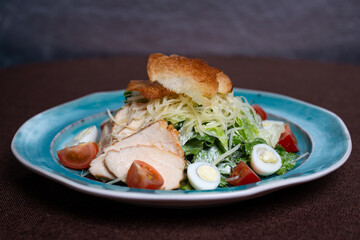 Caesar salad with chicken, fresh lettuce leaves and baked bread