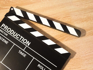 View of a clapperboard on a wooden background. Concept of video production, series, movies, films, feature films, film industry.