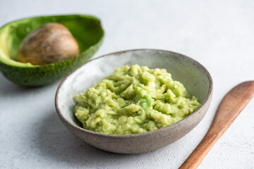 Bowl of mashed avocado puree. Cosmetics, edible food sauce, toast topping - 612952624