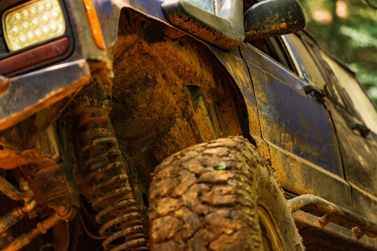 Closeup view of a 4x4 truck going over muddy obstacles, from ground level