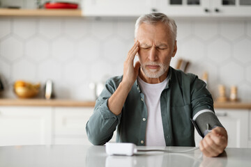 Hypertension. Senior Man Checking Blood Pressure With Upper Arm Monitor At Home