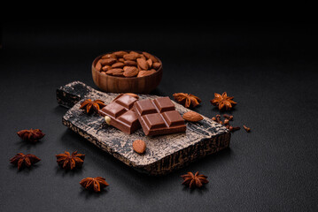 Delicious sweet milk chocolate broken into cubes on a wooden cutting board