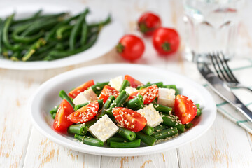 Plate with delicious green beans salad on wooden table, closeup.
