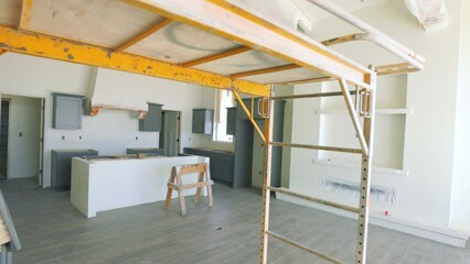 New Southwest Home Construction Freshly Painted Move Under Scaffolding to Kitchen. slow motion view in new home construction freshly painted interior moving under scaffolding toward kitchen