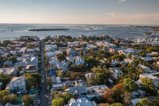 Aerial view of downtown Key West, Florida cityscape and ocean coastal landscape neighborhood with houses and businesses during golden hour sunset 