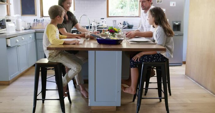 Happy family, food and conversation in home for eating dinner with mom, dad and with kids together in kitchen. Lunch, mother and father talking with children for quality time at meal table in house