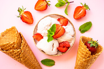 Homemade ice cream with fresh strawberries on pink background. Flat lay.