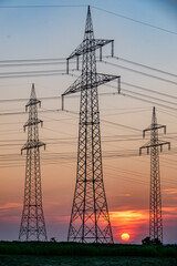 Sonnenuntergang hinter Strommasten einer &Uuml;berlandleitung