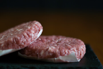 Raw hamburgers on a slate board
