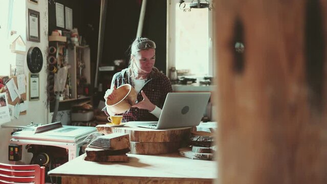 Female carpenter using laptop in a carpentry workshop

