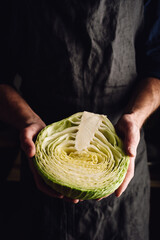 Man is Holding Half of White Cabbage in Hands