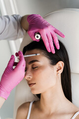 Fototapeta premium Mesotherapy injections in hair of girl. Mesotherapy injections of vitamins, enzymes, hormones, and plant extracts to rejuvenate and tighten skin, as well as remove excess fat.