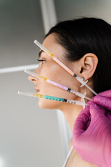 Girl with vitamin cocktail syringes for injections close-up. Mesotherapy injections of vitamins, enzymes, hormones, and plant extracts to rejuvenate and tighten skin and remove excess fat.