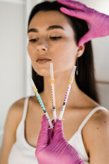 Girl with vitamin cocktail syringes for injections. Mesotherapy injections of vitamins, enzymes,...