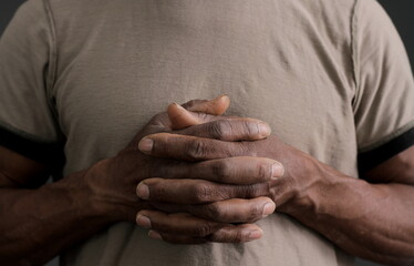 Fototapeta premium man praying to god with hands together on dark background stock photo 